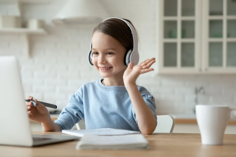 Young girl focused on learning activity, smiling confidently at ZPD: Zionsville Pediatric Dentistry