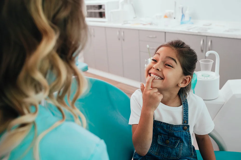 Smiling young girl showing her teeth to the dentist during a checkup at ZPD: Zionsville Pediatric Dentistry