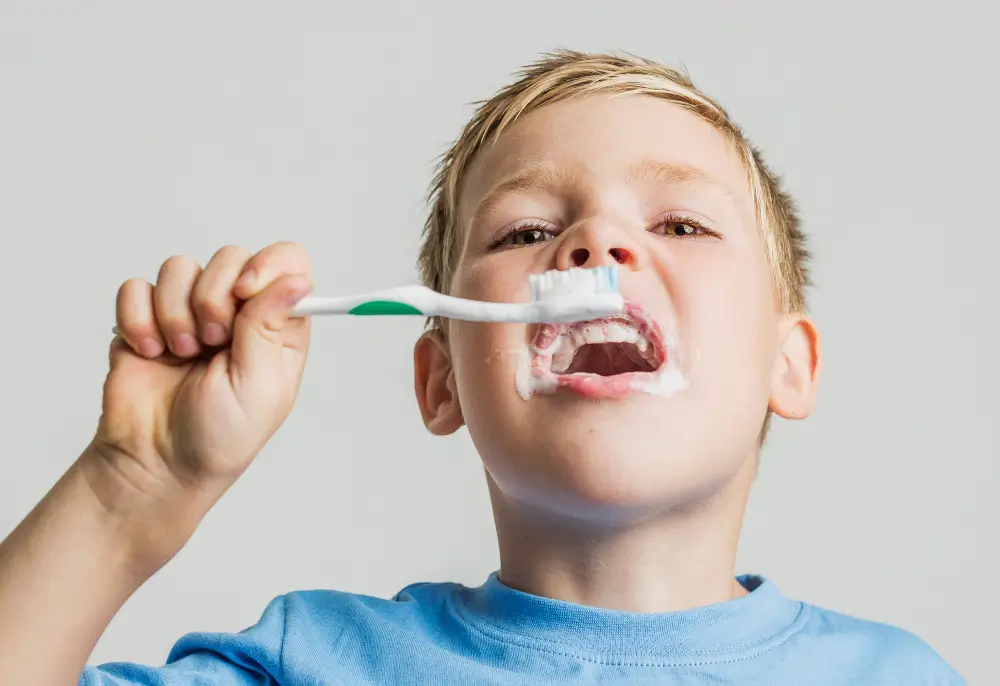 Young child learning the first steps to oral health by brushing teeth