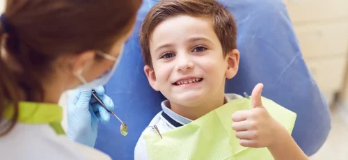 Happy child giving thumbs up after dental exam at ZPD Dental Clinic, showing a bright, healthy smile