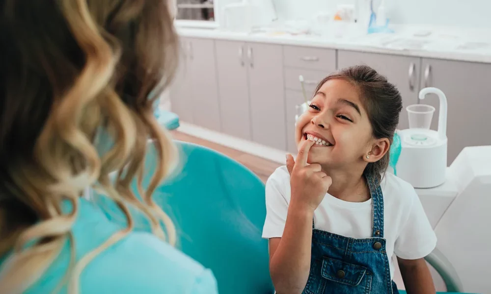 Smiling young girl showing her teeth to the dentist during a checkup at ZPD: Zionsville Pediatric Dentistry