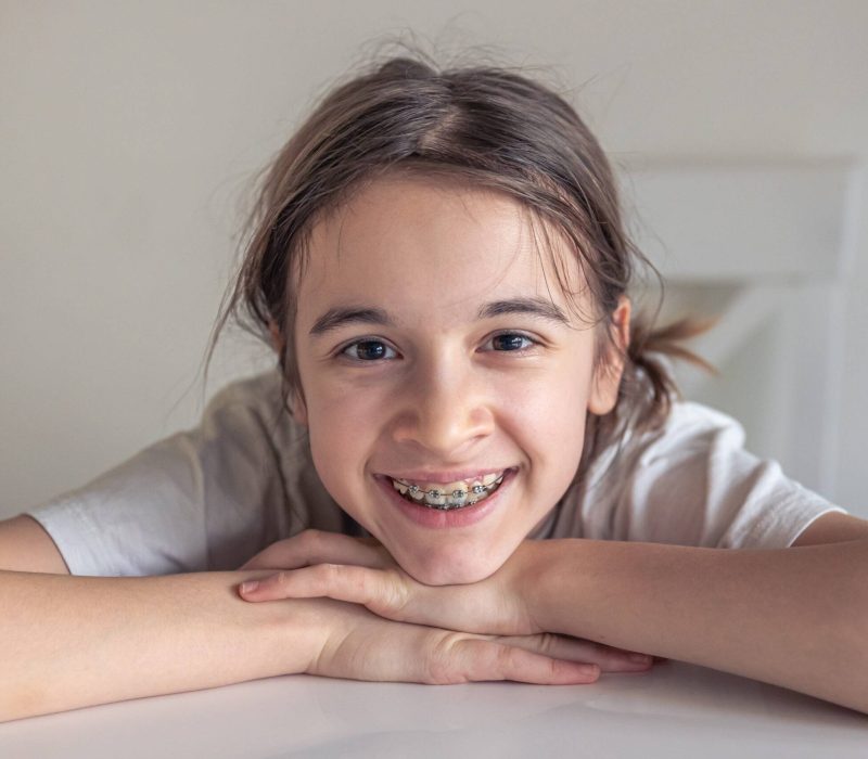 teenage girl smiling and showing her dental braces